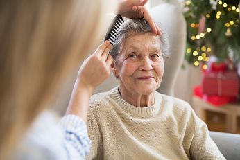 Alte Frau wird gekämmt