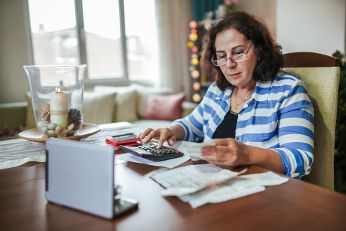 Frau rechnet mit Taschenrechner