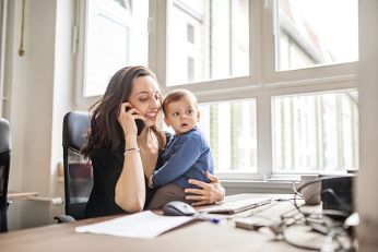 Woman working with toddler on her working-table.