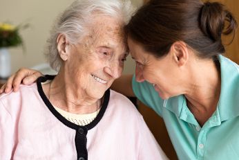 Woman caressing elderly woman.