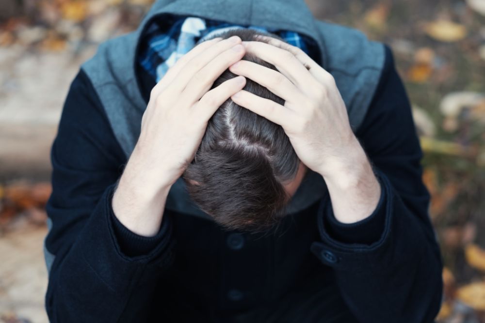 A person is holding his head in his hands.