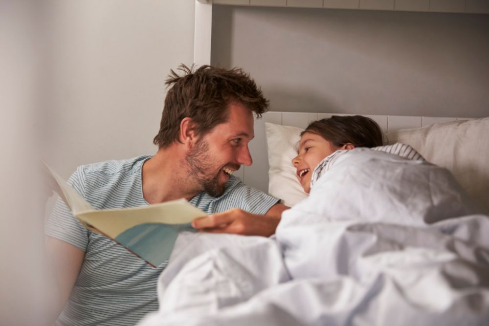 A father is reading a good night story to his child.