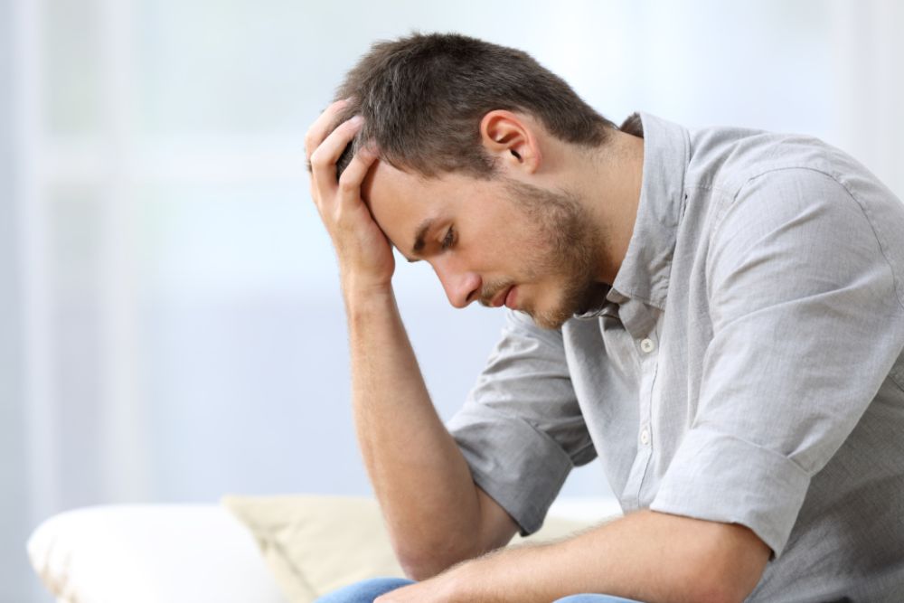 Desperate man sitting on his bed.