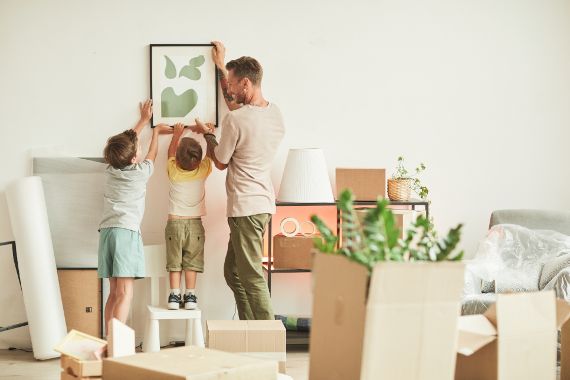 Vater hängt mit zwei Kindern Bild auf