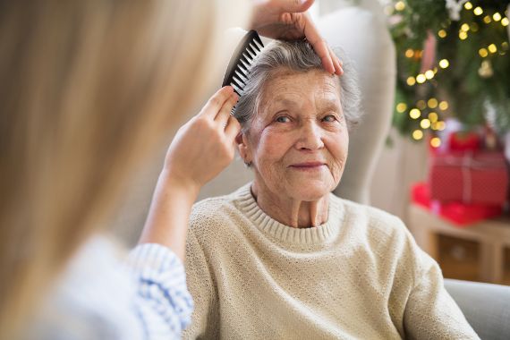 Alte Frau wird gekämmt