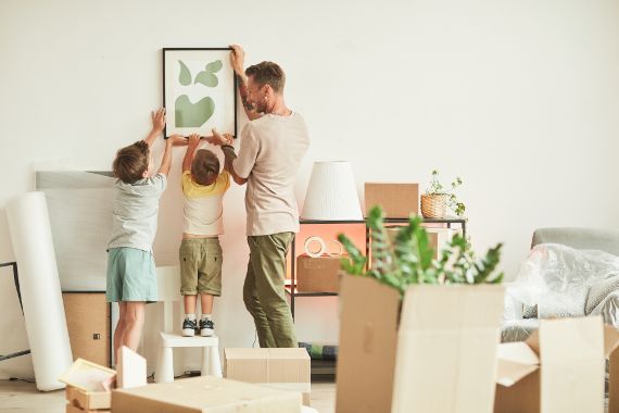 Father with children hanging a picture on the wall