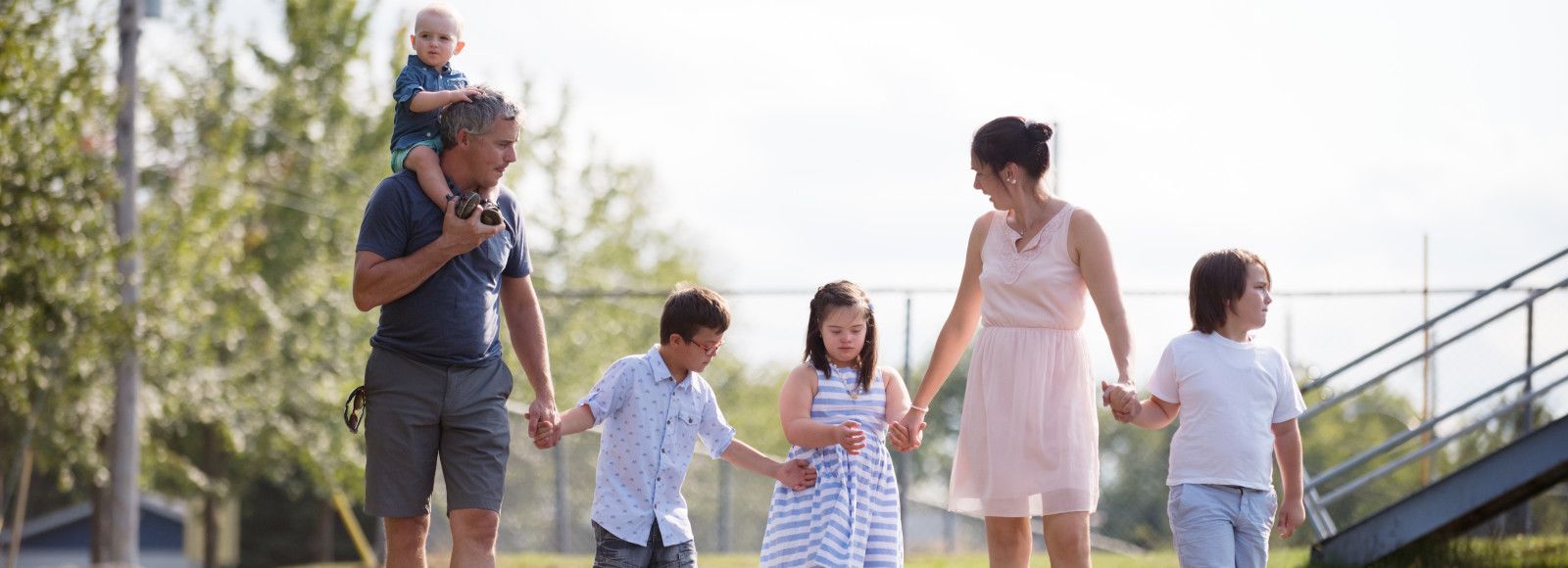  Family with 3 children goes for a walk, one of them with Down syndrome.