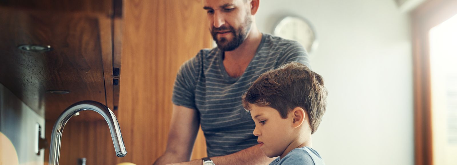  Father with son washing dishes.